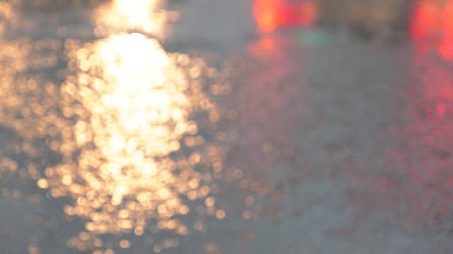 Raindrops creating ripples on a pavement