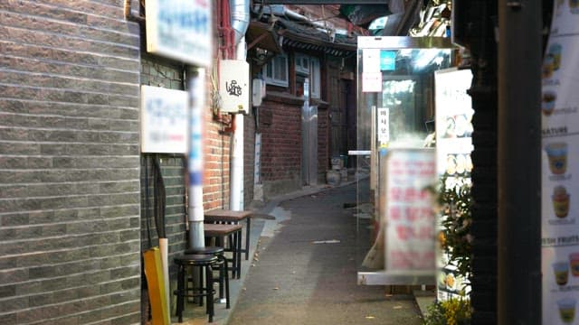Alleyway with dining spots and signs, evening