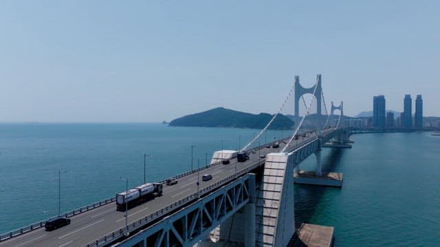 Gwangan Bridge over the blue sea leading to the city skyline of Busan