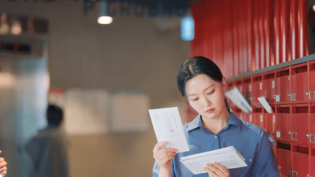 Woman checking mail in a building lobby