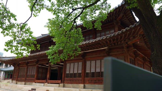 Historic wooden hanok with green trees