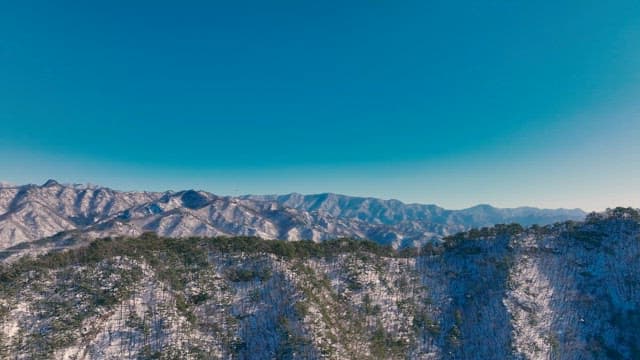 Snow-Covered Mountains Under a Clear Blue Sky