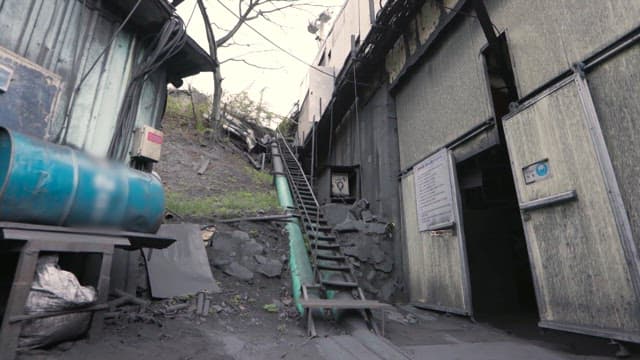 Old industrial facility with a staircase leading up a hill