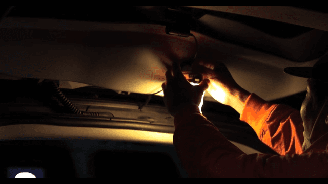 Person Attacheing Portable Lights to a Vehicle