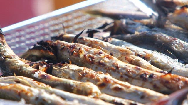 Grilling the sand eels until golden brown on the barbecue grill