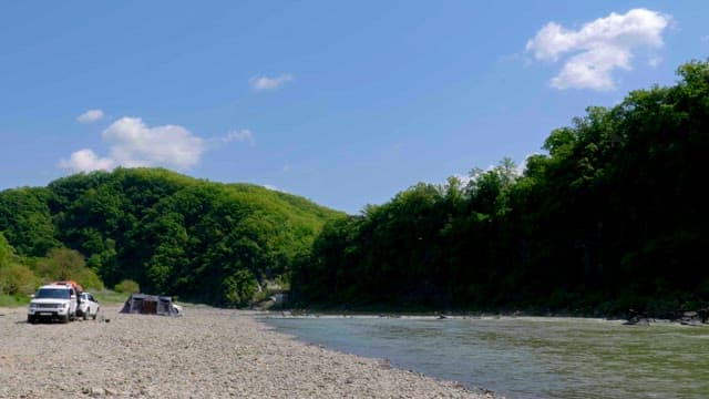 Riverside with cars and tents