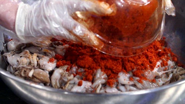 Mixing spicy seasoning with webfoot octopus