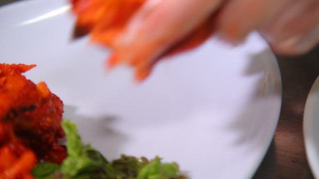 Kimchi being prepared on a white plate