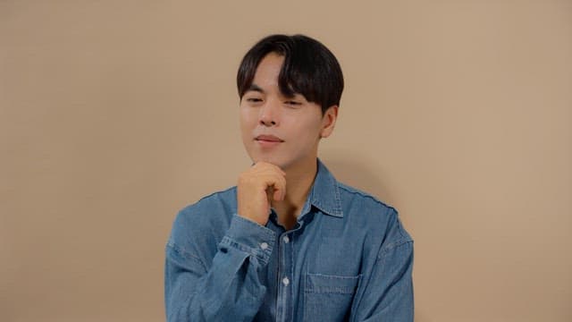 Man in denim shirt deep in thought