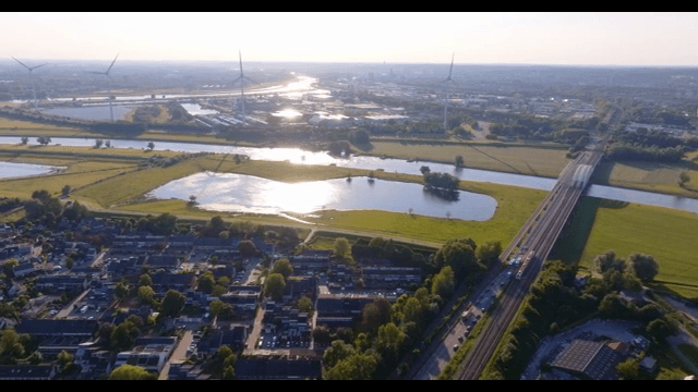 Scenic view of a river with wind turbines