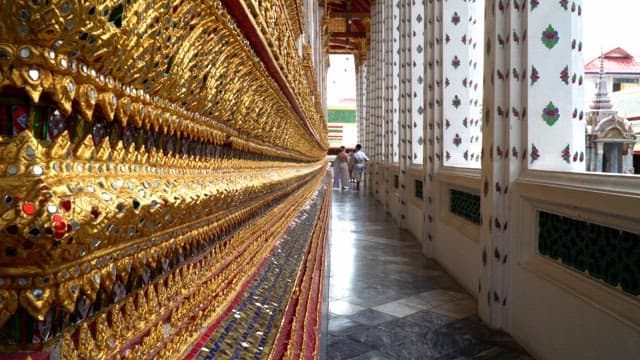 Hallway ornately decorated with gold and jewels, with people in it
