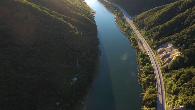 Aerial view of a road winding by a river