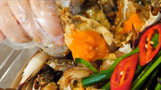 Spoonful of rice topped with soy sauce marinated crab meat