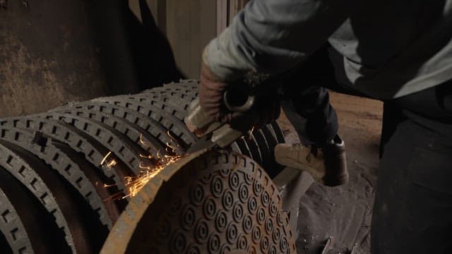 Worker grinding metal with sparks flying