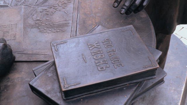 Bronze statue holding a pen and map