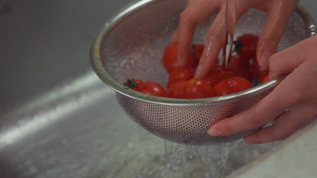 Washing fresh tomatoes in sink