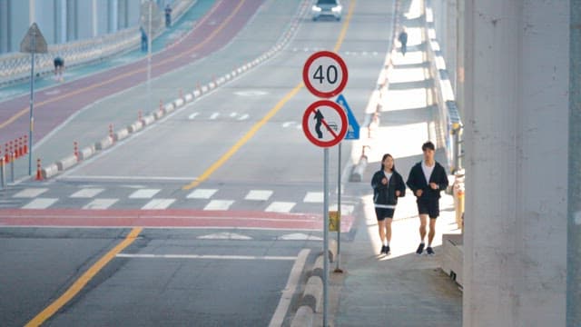 Couple jogging on jamsu bridge