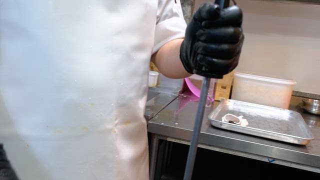 Chef sharpening a knife in a kitchen