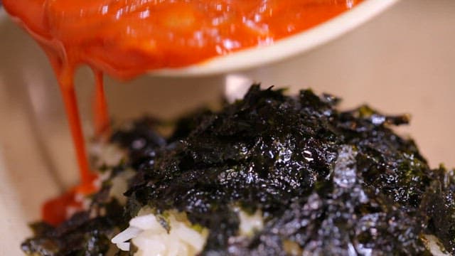 Serving tteokbokki soup with rice with seaweed
