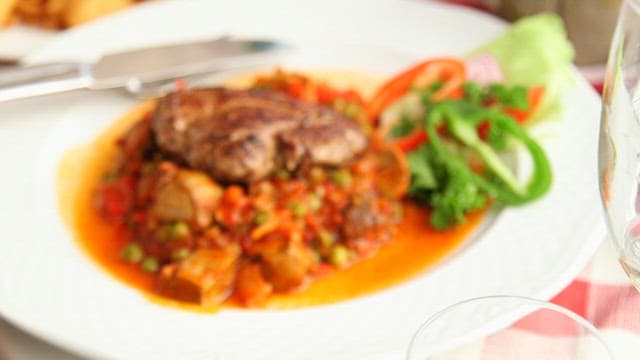 Deliciously Plated Steak with Vegetables and Sauce on a White Dish