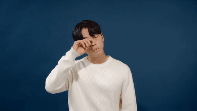 Sleepy man yawning wearing white sweater