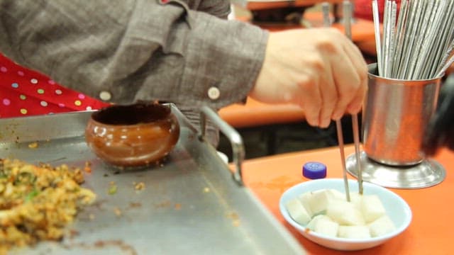 Spoonful of griddled stir-fried rice served with pickled radish