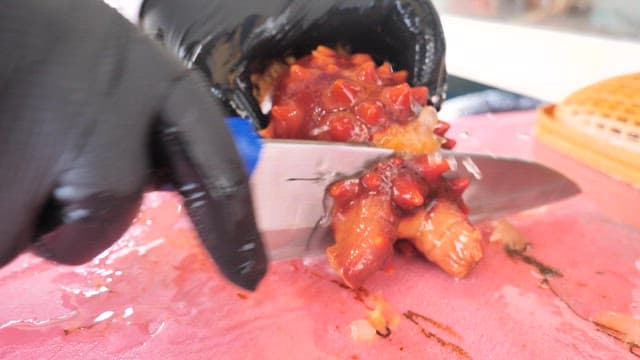 Fresh sea pineapple being prepared and plated on a cutting board in the market