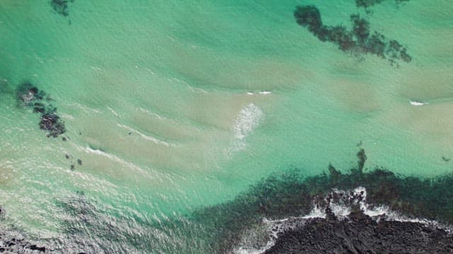 Aerial view of a turquoise sea with gentle waves