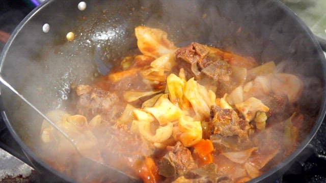 The process of cooking food with vegetables and meat in red soup