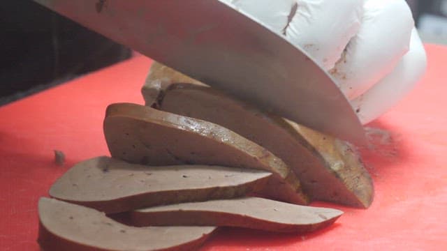 Man Slicing Pork Liver on Red Cutting Board