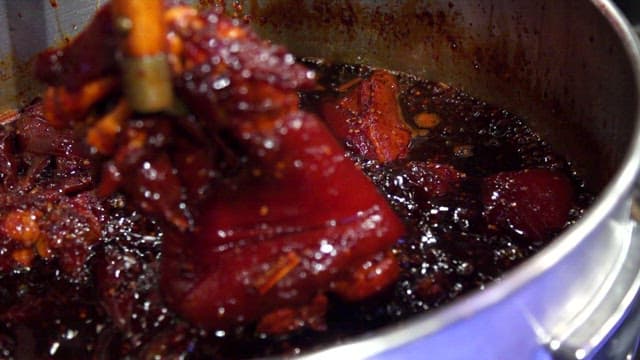 Braised pigs' feet boiling in a sot