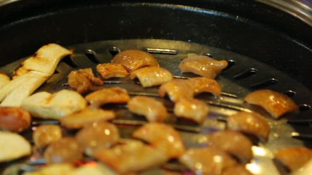 Pork rinds on the grill picked up with chopsticks