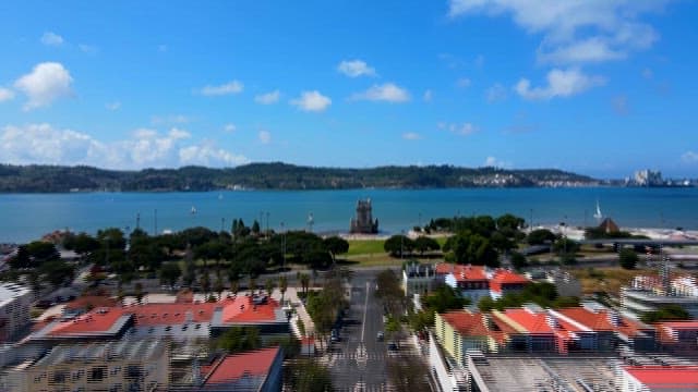 Clear Day View of Belém Tower by the Water with Tourists