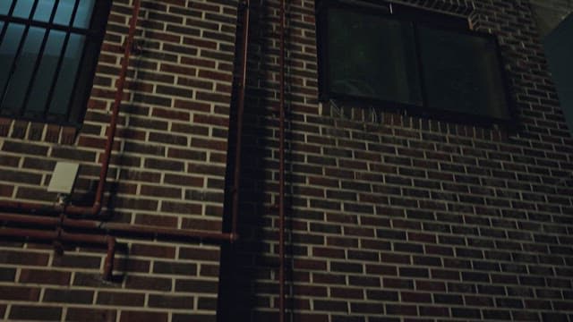 Thief Climbing a Pipe on an Urban Building