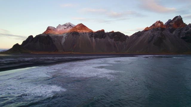 Serene beach with waves and mountains