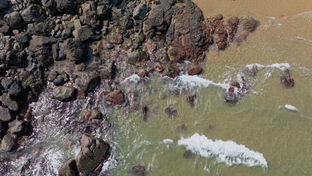 Rocky shoreline with clear waves crashing against the rocks