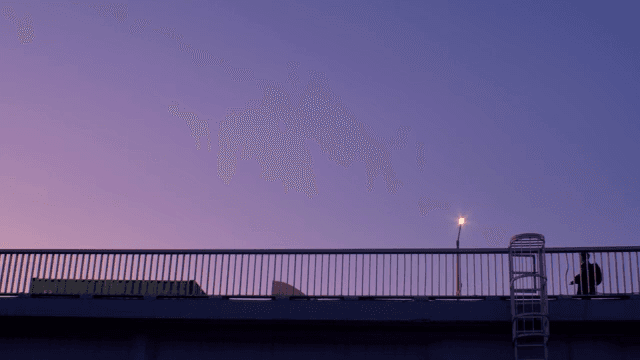 Person walking on a bridge at dusk