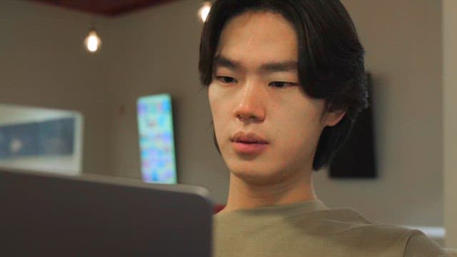 Man focused on a laptop indoors