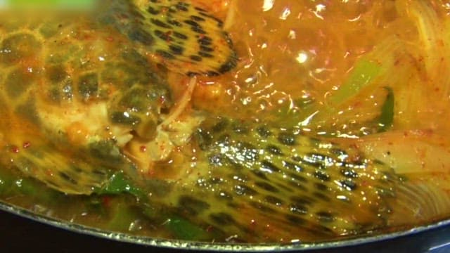 Spicy fish stew with vegetables boiling in a pot