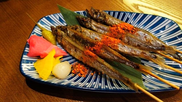 Grilled shisamo skewers neatly placed on a plate