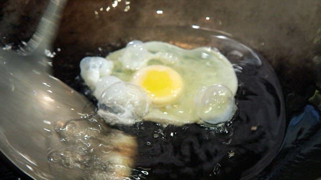 Egg frying in a hot pan with hot oil