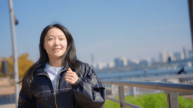 Woman jogging along a riverside path