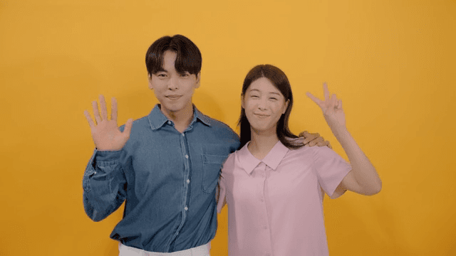 Man and a woman smiling affectionately while looking straight ahead