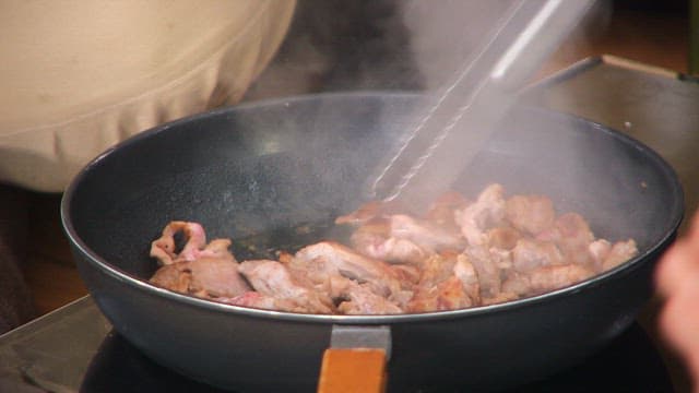 Skirt meat and garlic being cooked in a pan