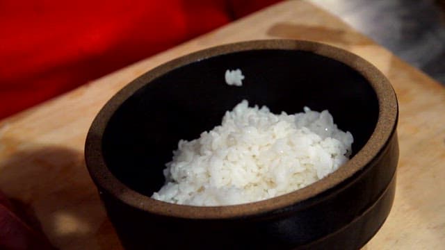 Rice and chicken being prepared in a bowl