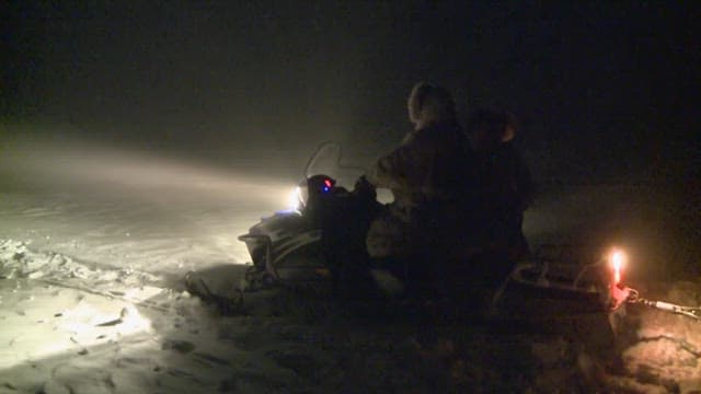 People riding snowmobiles in the snow