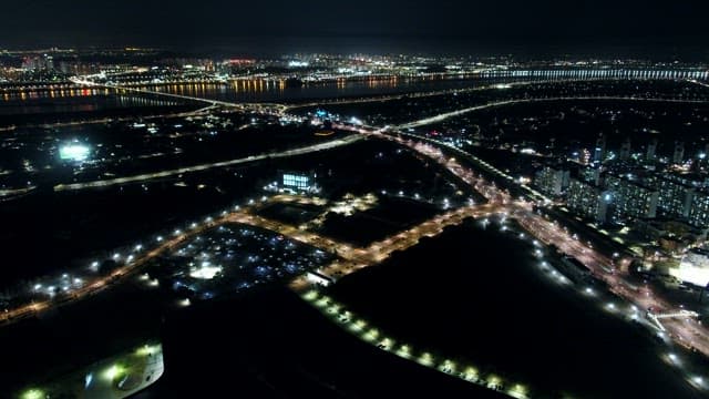 City lights bordering a tranquil river at night