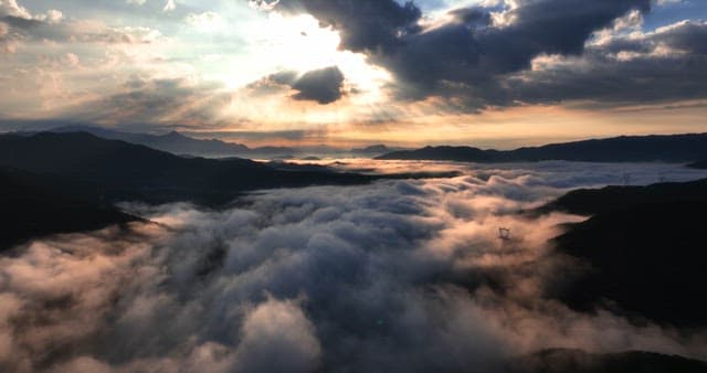 Clouds covering mountains at sunrise