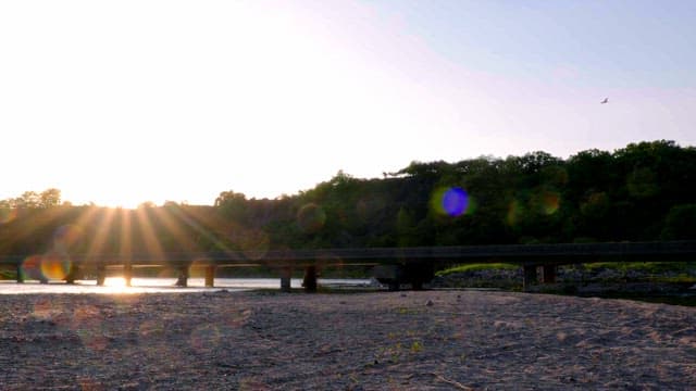 Sunset over a tranquil river and bridge
