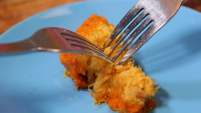 Fork cutting into crispy fried chicken